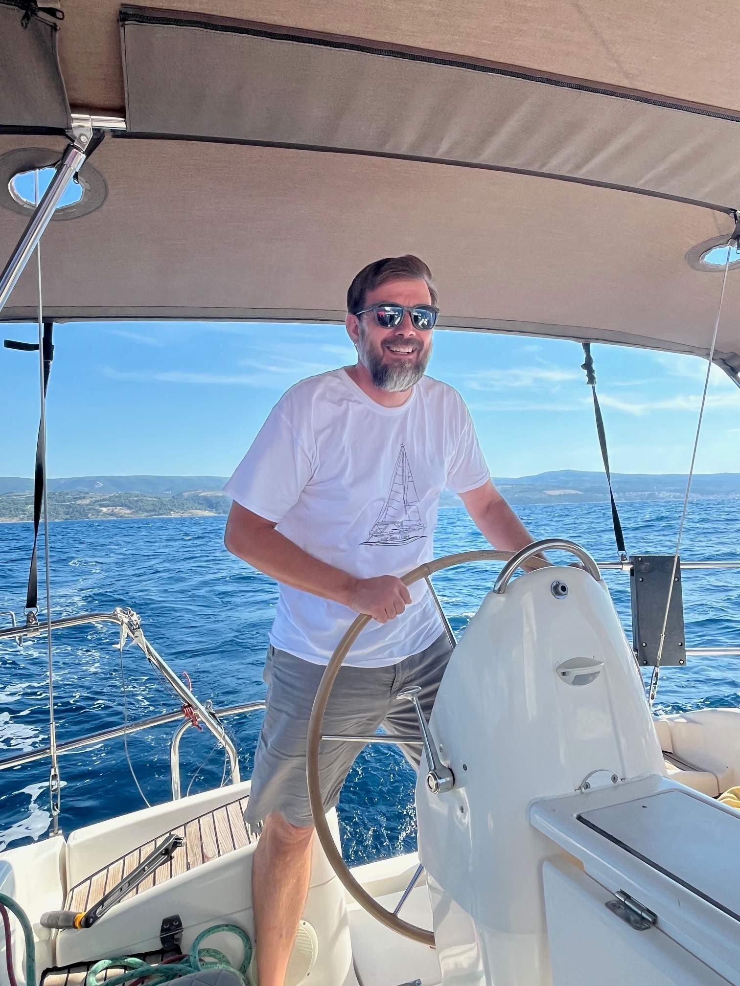 Captain Mario at the helm of the sailboat Nana